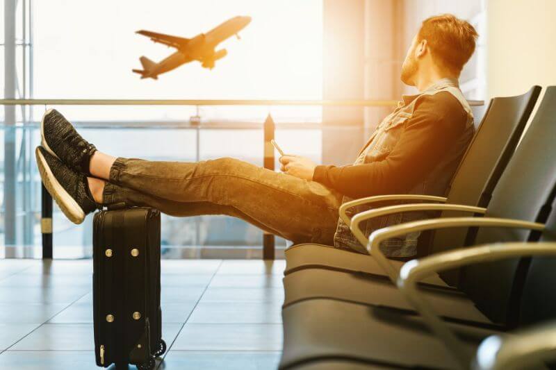 At the airport with feet resting on suitcase