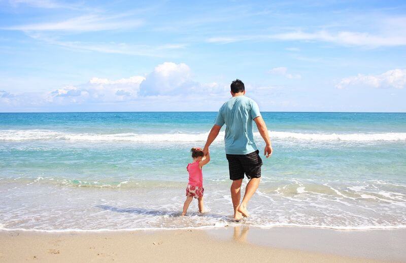 father and daughter at beach with no foot problems stopping their fun.