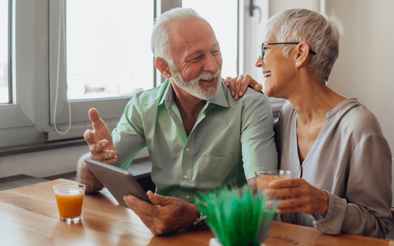 Older couple sat at a table talking about Parkinson’s Disease