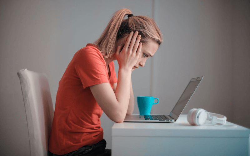 Lady hunched over her laptop - a cause of bad posture.