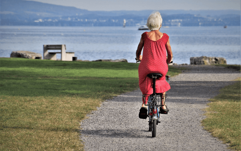 older lady cycling to improve her health and fitness