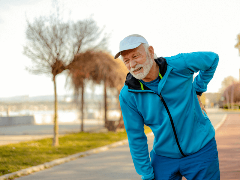 man out walking, struggling with back pain - possibly as a result of poor foot health