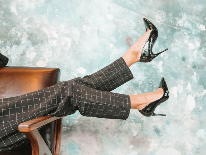 woman wearing high heels over the arm of a chair.
